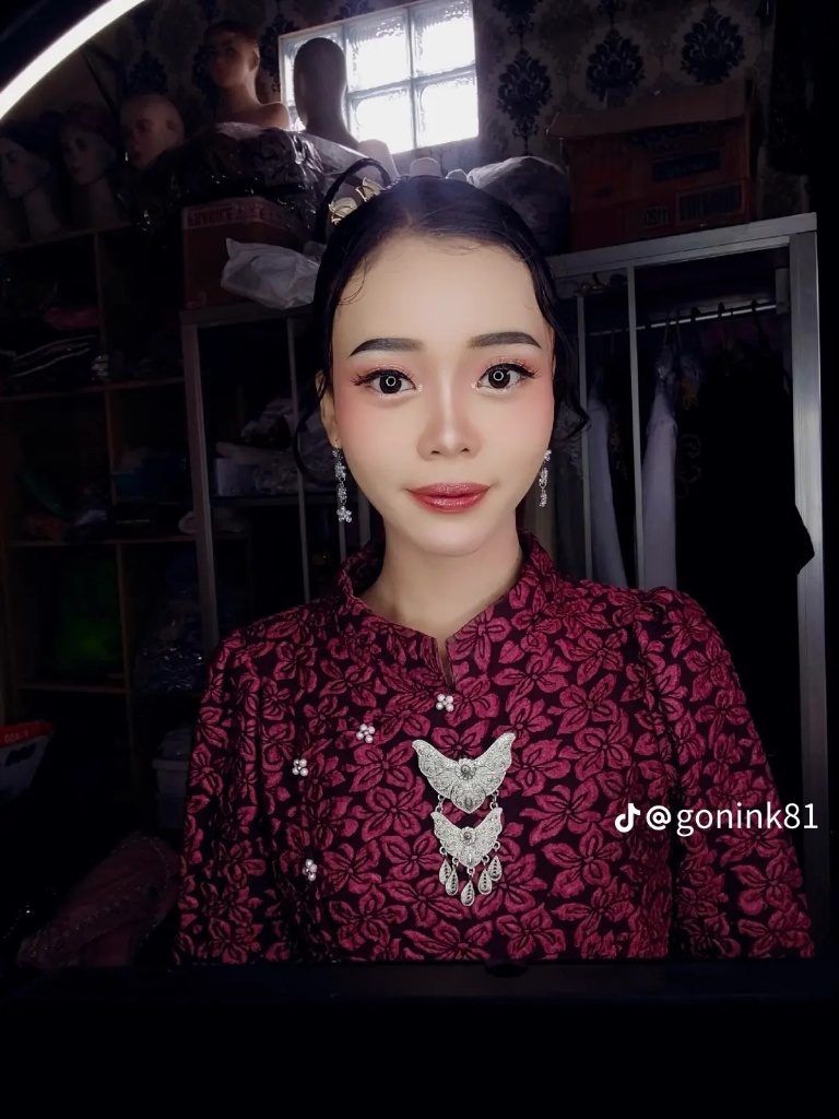 Potret riasan dengan sanggul dan kebaya batik merah tua, difoto di ruang rias.