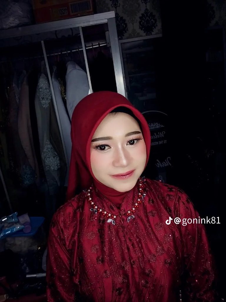 Potret riasan dengan kerudung merah marun dan kebaya bersulam, diambil di ruang rias.