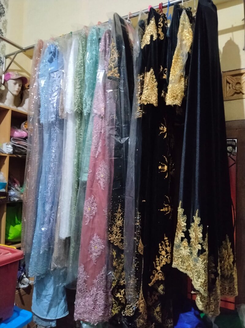 Rak kebaya warna pastel berdampingan dengan gaun hitam bersulam emas.